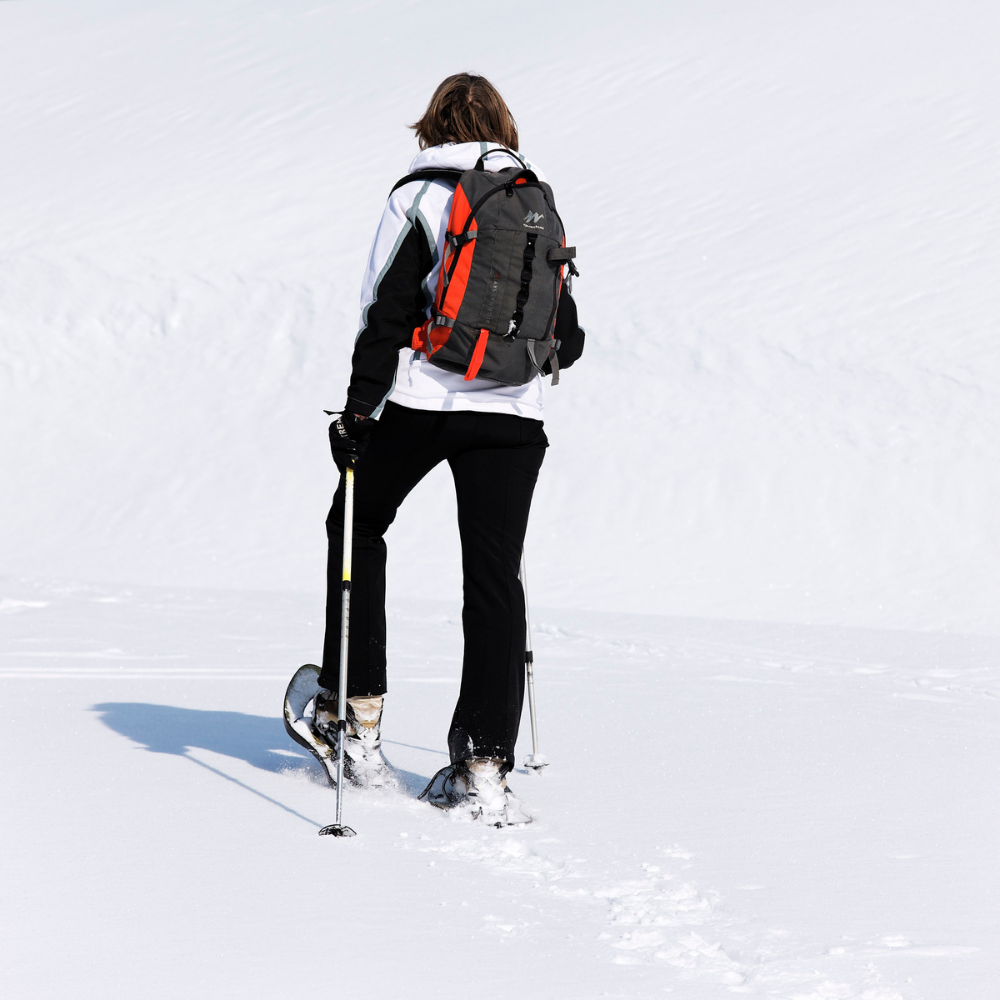 Person snowshoeing in the snow with a backpack
