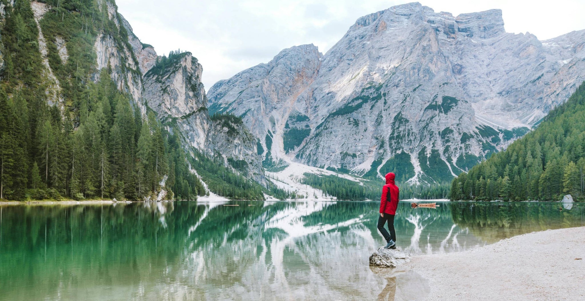 Persona in piedi in un paesaggio panoramico norvegese con fiume, foresta e montagne sullo sfondo