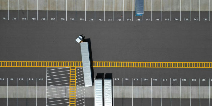 Vista dall'alto di un ampio parcheggio con alcuni camion.