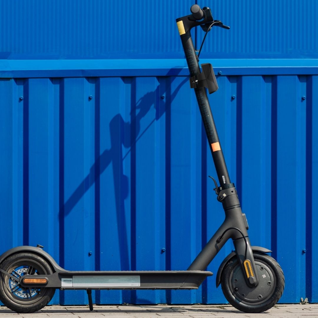 Scooter elettrico nero su sfondo blu in lamiera ondulata